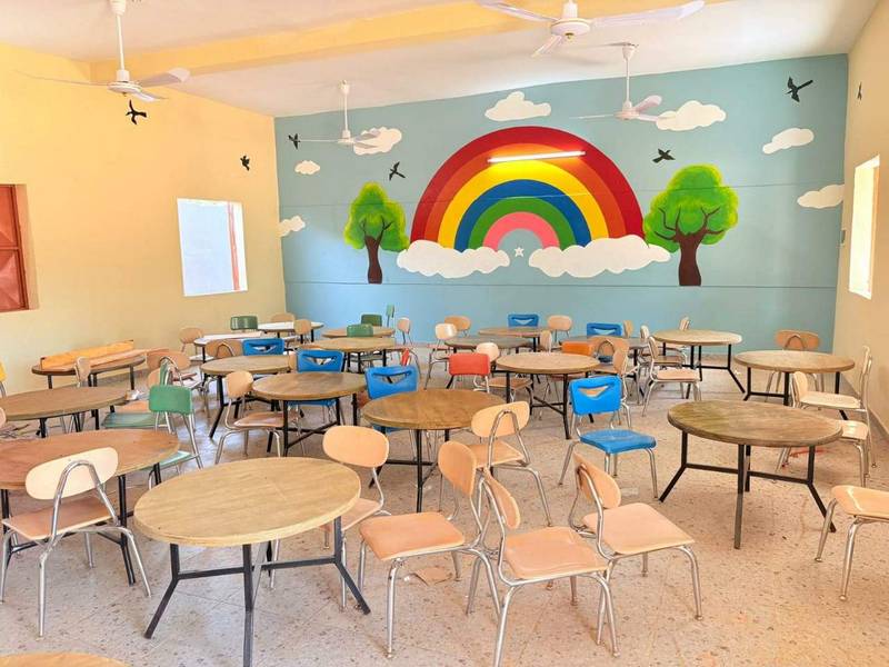 Salle de classe colorée avec fresque arc-en-ciel